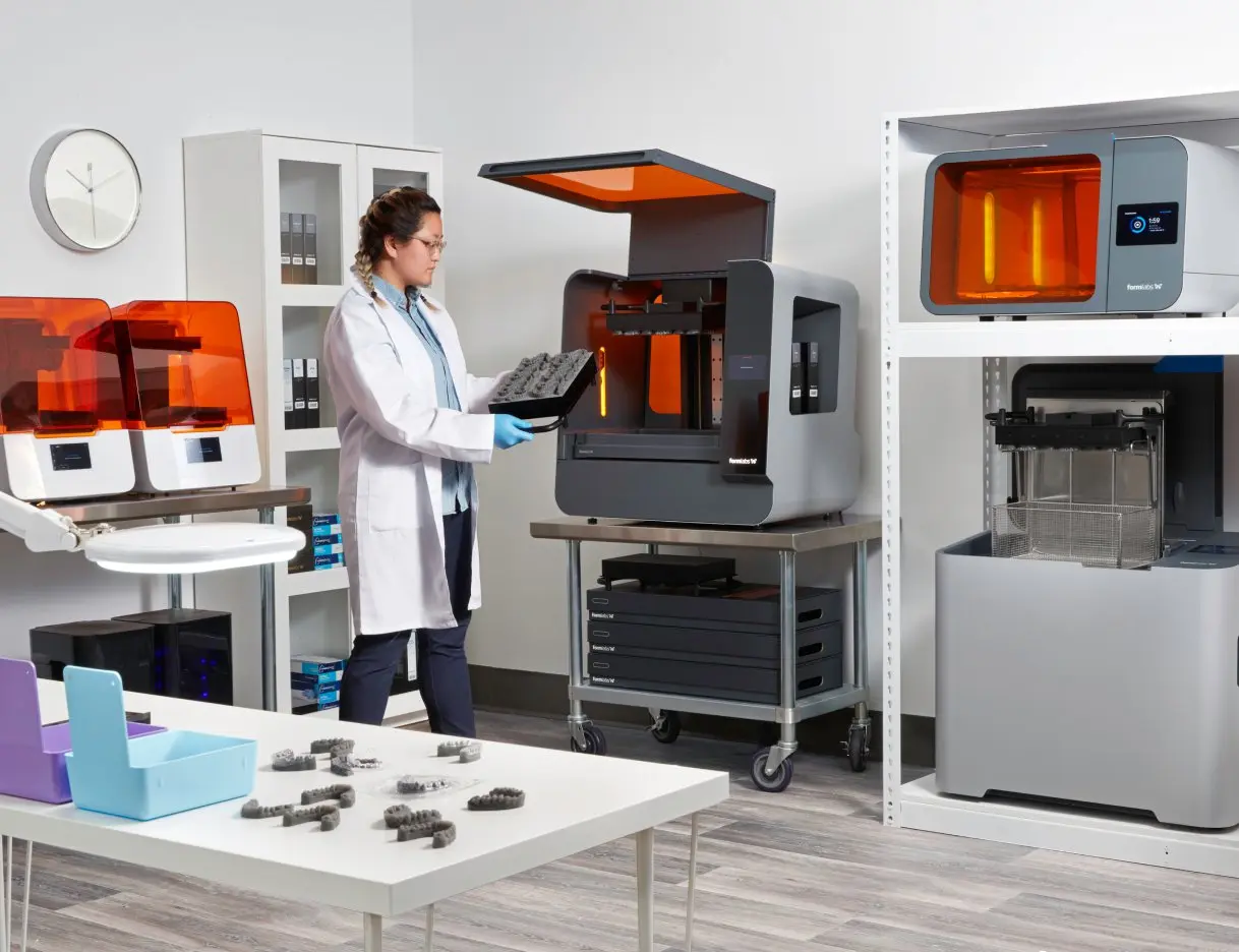 Image shows dental technician in a lab equipped with Formlabs 3D printer, Form Wash L and Form Cure L