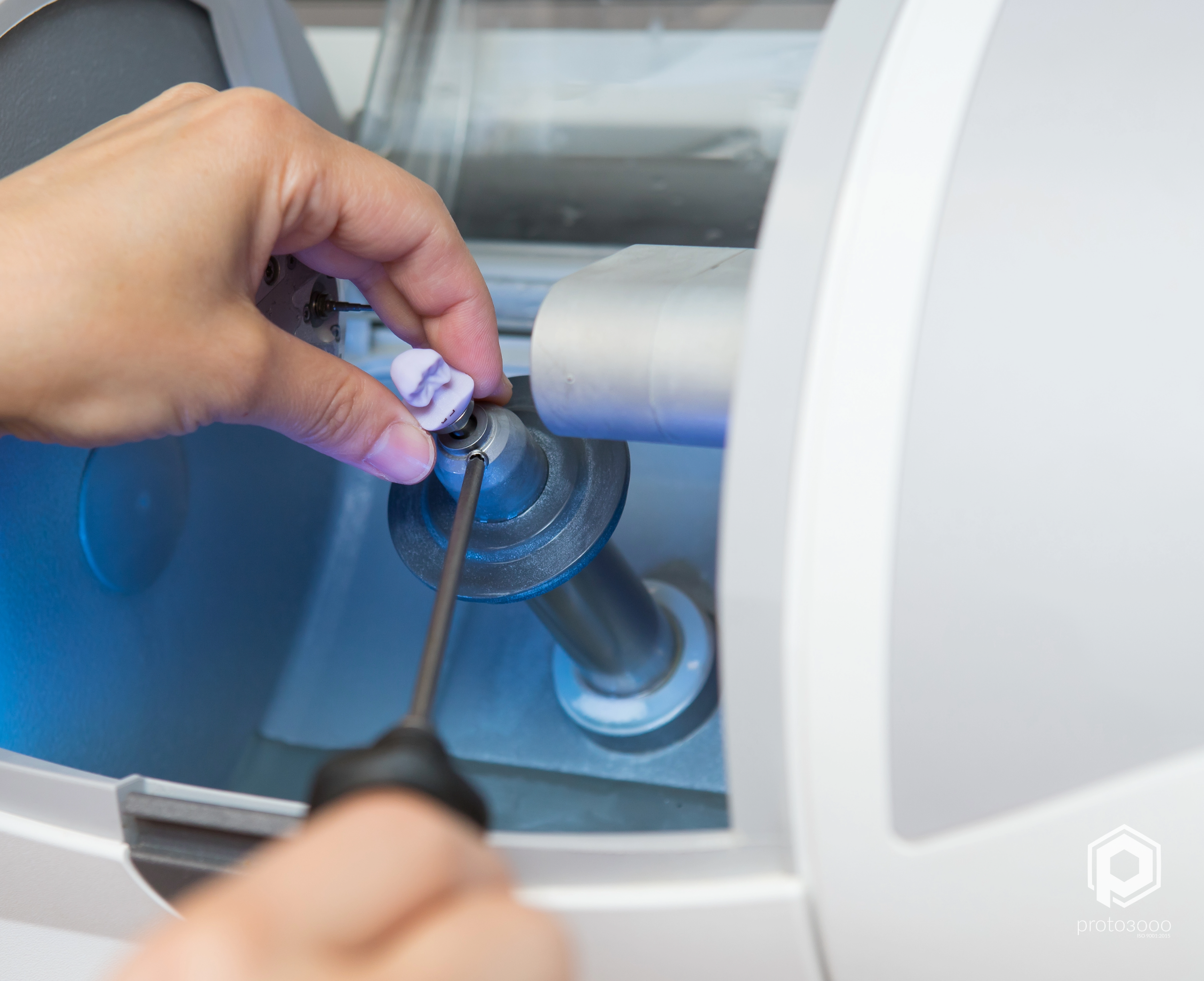 Image shows a technician working on a dental milling machine