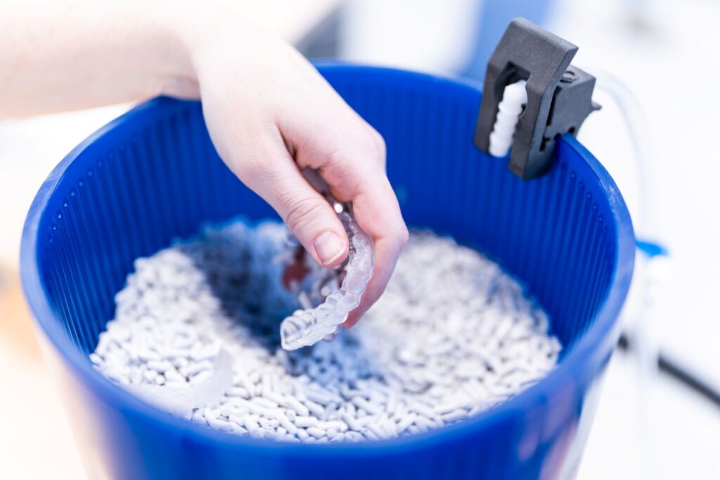 image of a Maxi Dental bucket with polishing media and a finished transparent bite splint