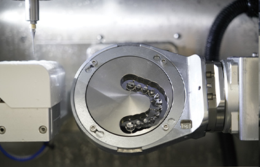 Interior view of an Aidite dental milling machine fabricating a full-arch cobalt-chromium or titanium implant bridge framework from a metal disc
